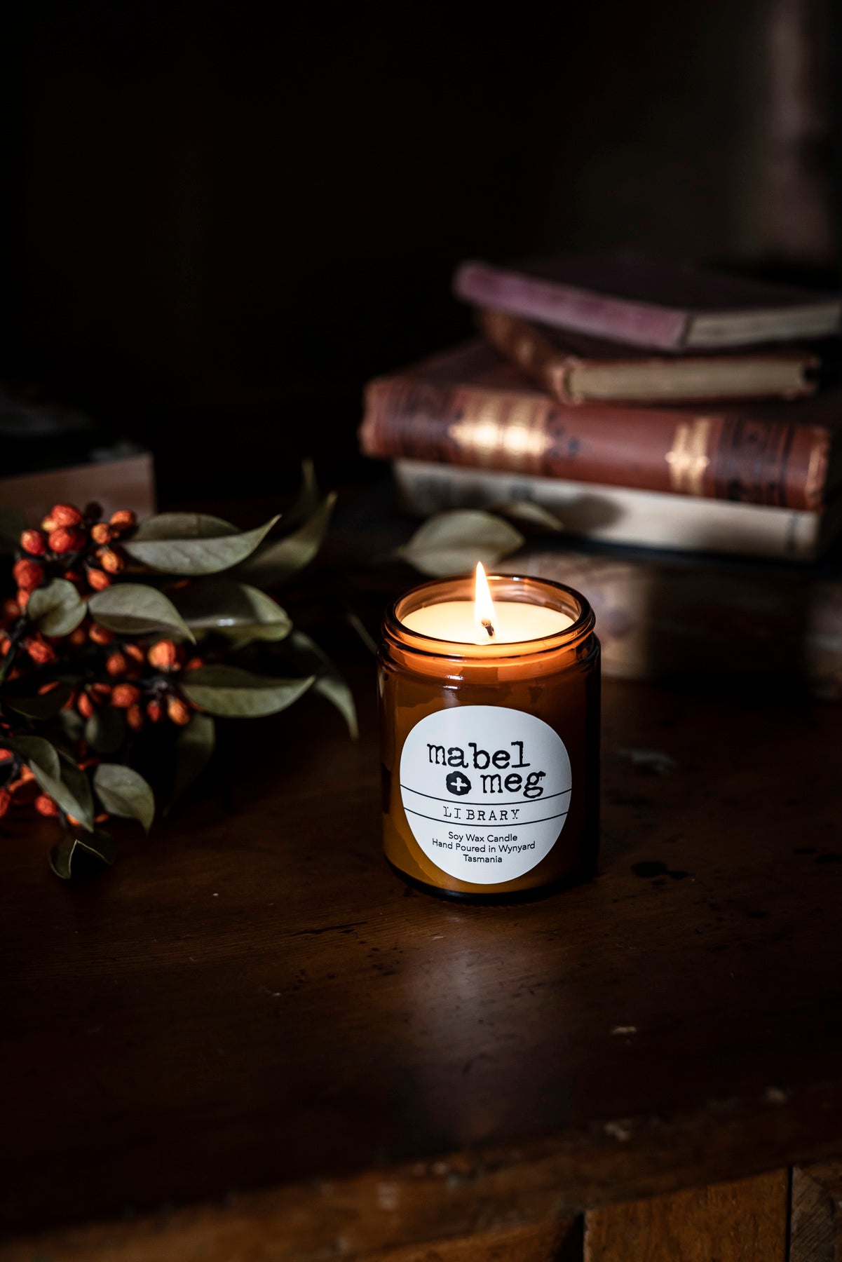Library soy candle by mabel + meg sitting next to books